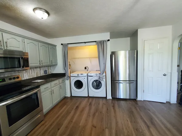 a kitchen with a refrigerator and a stove top oven