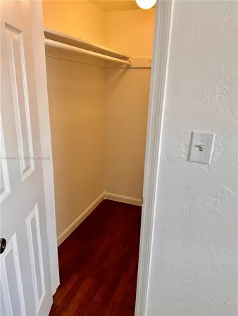 a view of a small space with wooden floor and a window