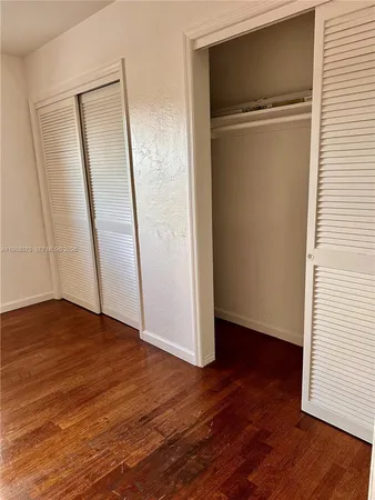an empty room with wooden floor and a window