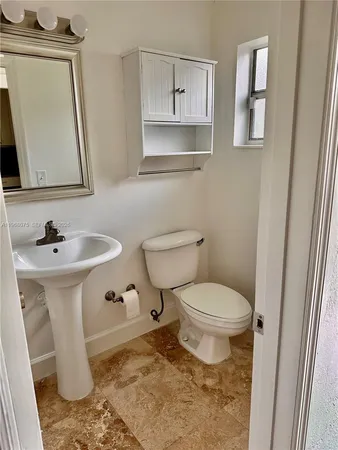 a bathroom with a toilet sink and mirror