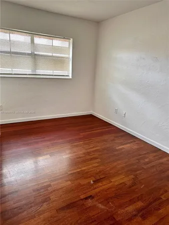 a view of a room with wooden floor and window