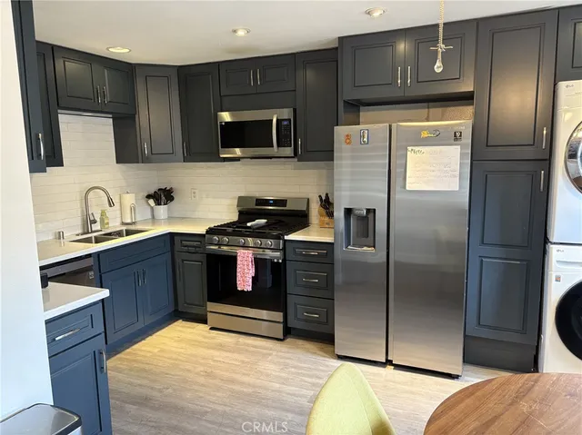 a kitchen with stainless steel appliances kitchen island granite countertop a refrigerator stove and microwave