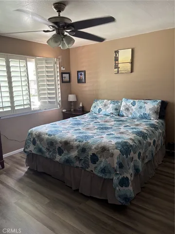 a bedroom with a bed wooden floor and window