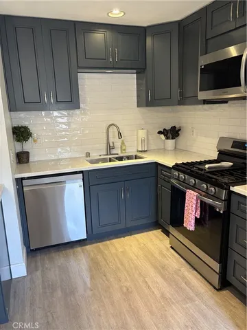 a kitchen with stainless steel appliances granite countertop a stove a sink and a microwave