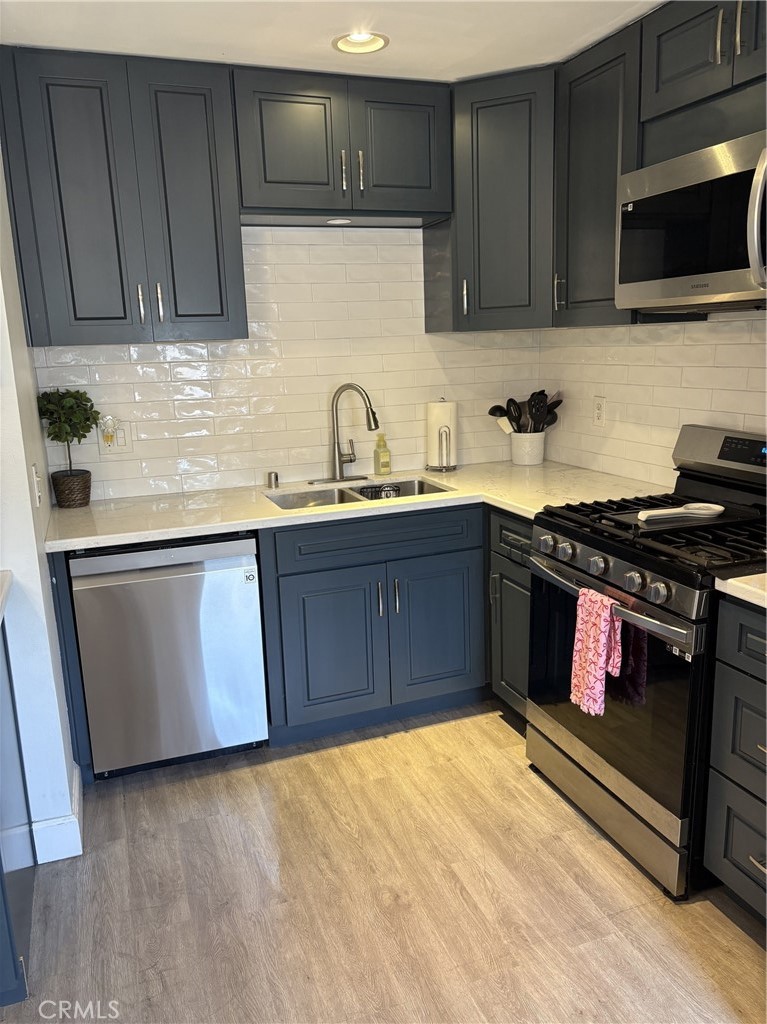 4731 Rey Drive, Unit 133 Huntington Beach, CA 92649 - Photo 10 of 31 a kitchen with stainless steel appliances granite countertop a stove a sink and a microwave