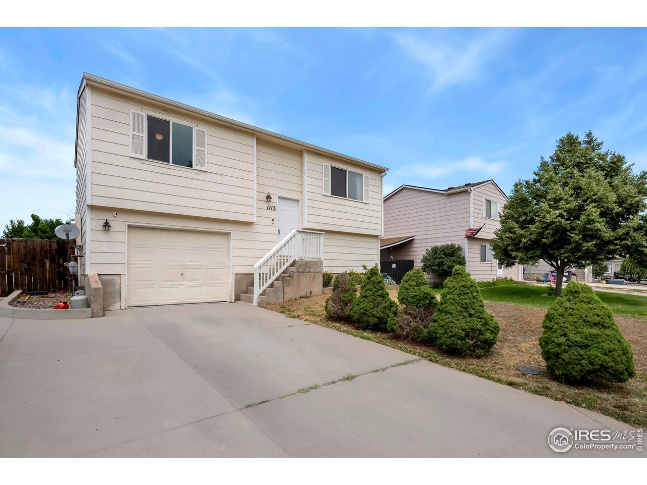1113 East 24th Street Road Greeley, CO 80631 - Photo 2 of 25 a front view of a house with a yard and garage