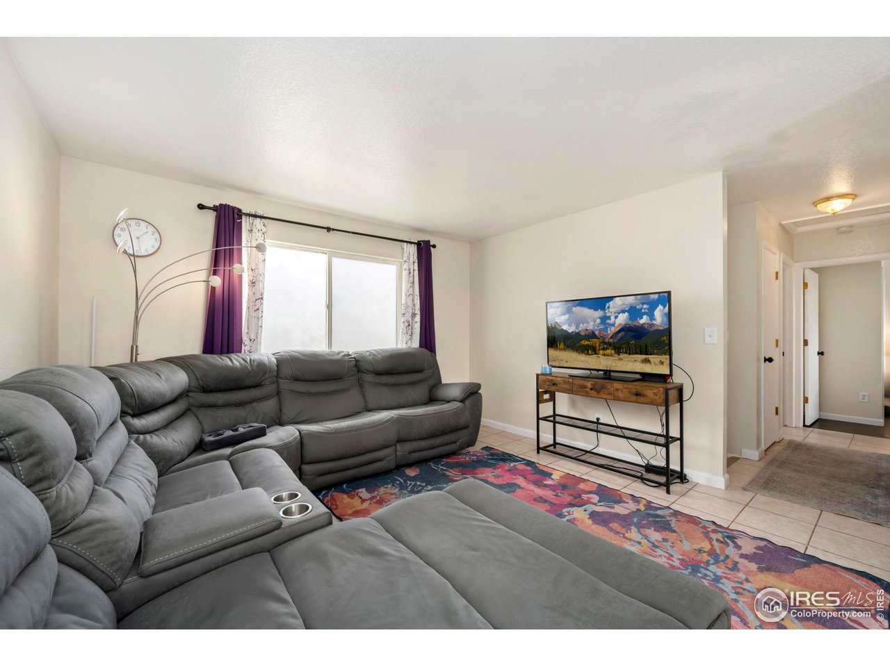 1113 East 24th Street Road Greeley, CO 80631 - Photo 5 of 25 a living room with furniture a flat screen tv and a window