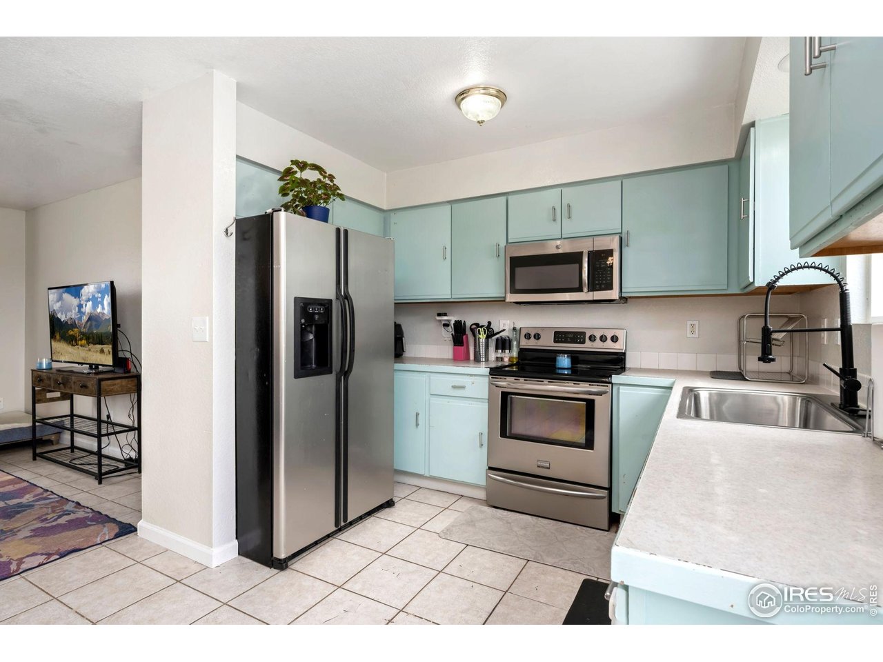 1113 East 24th Street Road Greeley, CO 80631 - Photo 6 of 25 a kitchen with granite countertop a refrigerator and a stove top oven