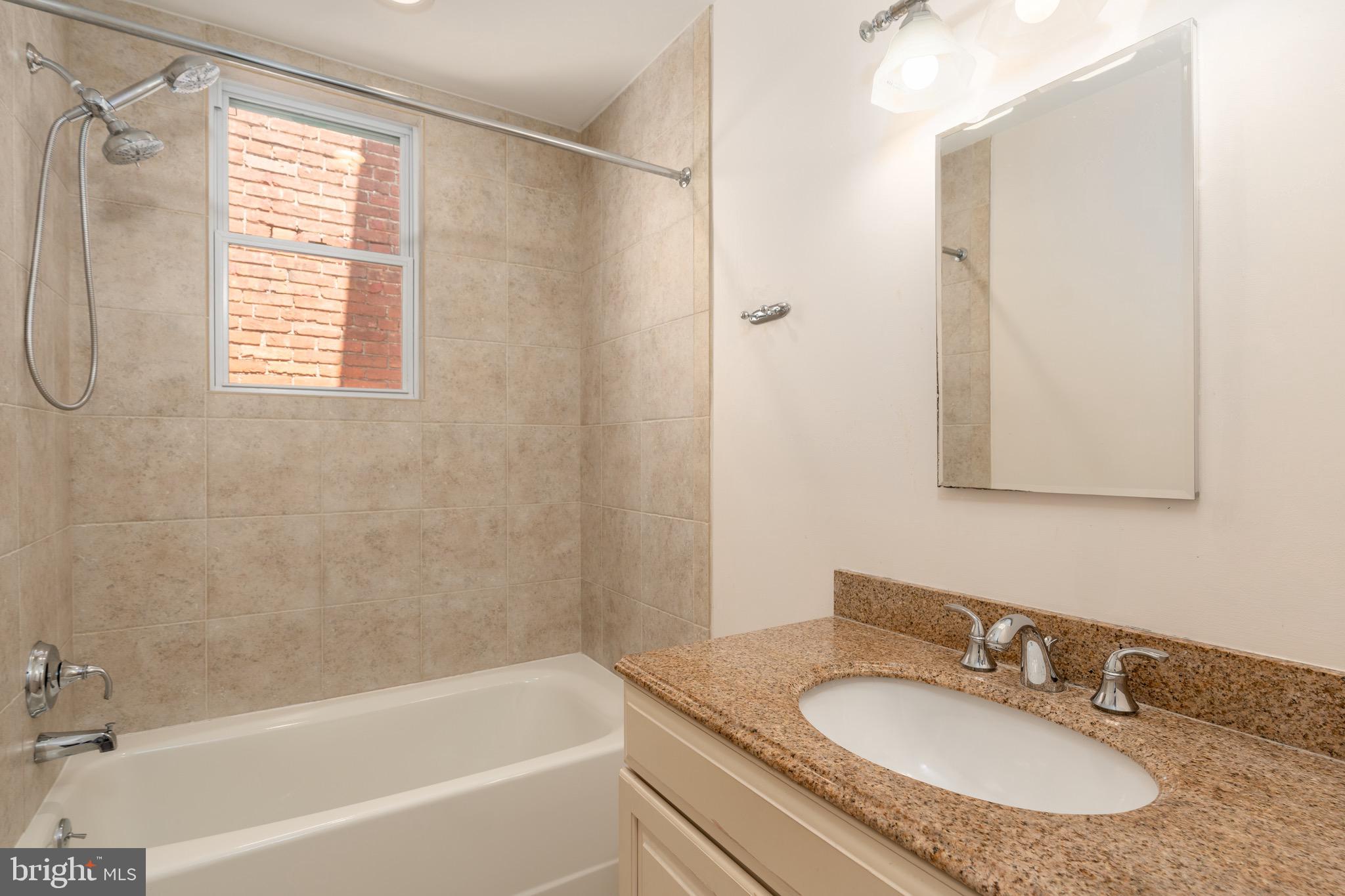 1716 22nd Street Northwest Washington, DC 20008 - Photo 21 of 40 a bathroom with a granite countertop sink a mirror and a bathtub