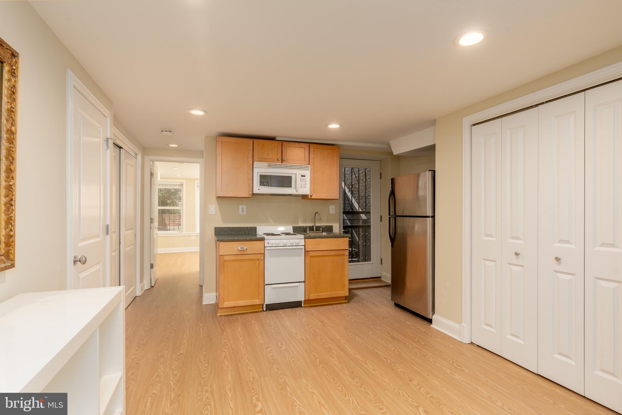 1716 22nd Street Northwest Washington, DC 20008 - Photo 34 of 40 a open kitchen with white cabinets and stainless steel appliances