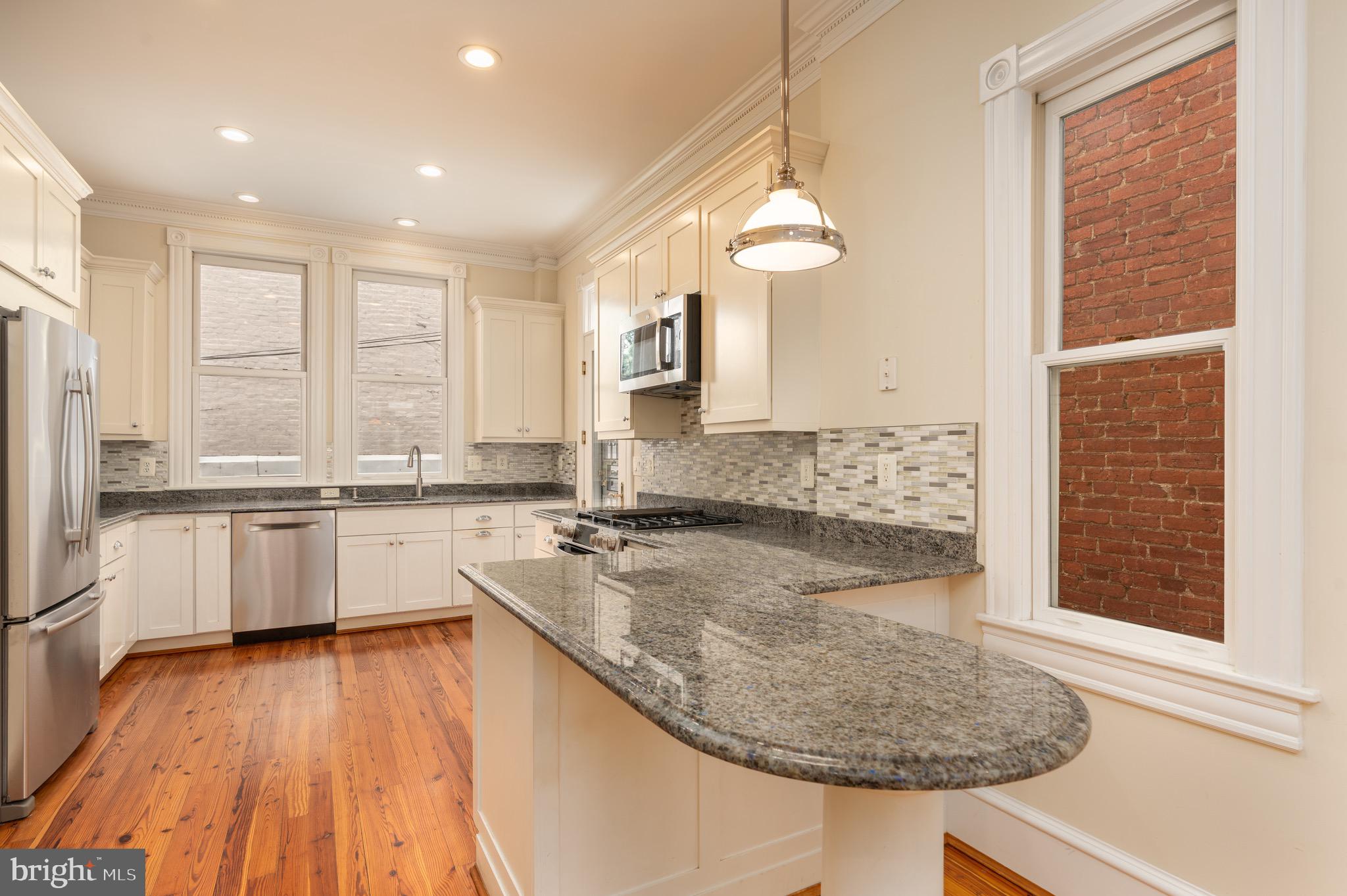1716 22nd Street Northwest Washington, DC 20008 - Photo 8 of 40 a kitchen with a sink window and cabinets