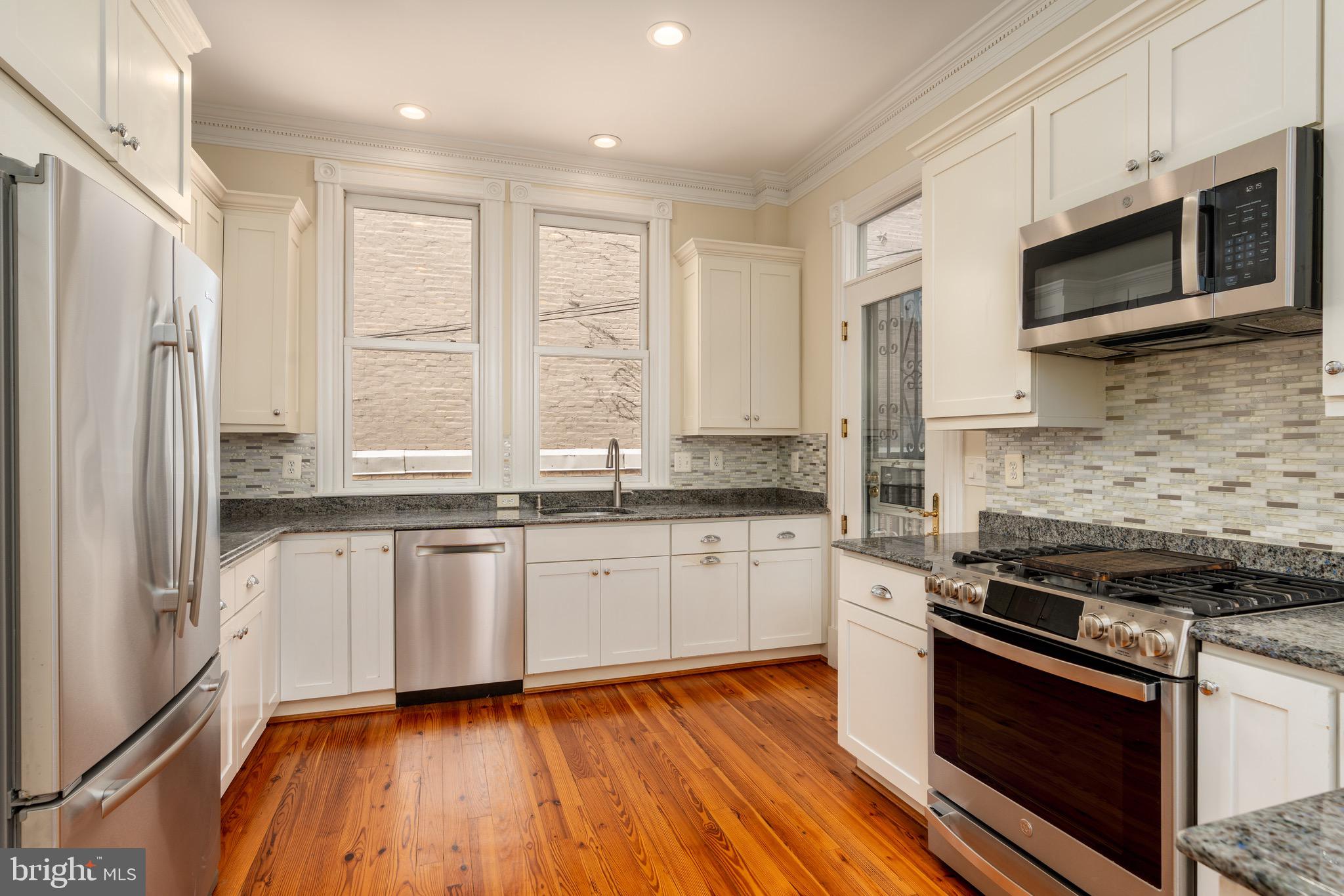 1716 22nd Street Northwest Washington, DC 20008 - Photo 9 of 40 a kitchen with stainless steel appliances granite countertop a stove a sink and a refrigerator