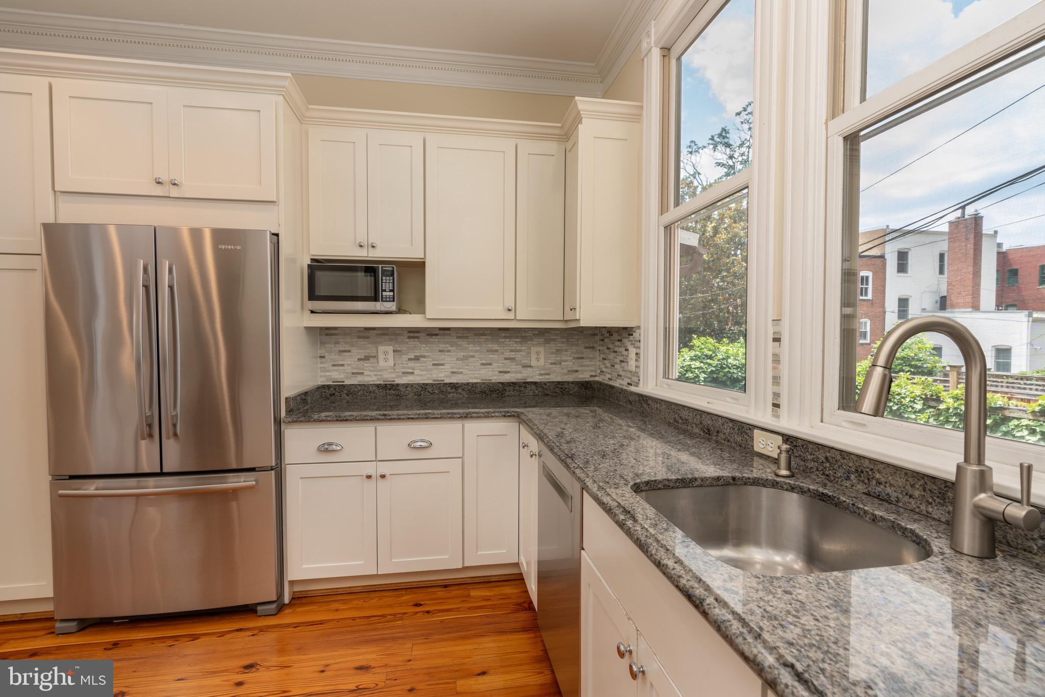 1716 22nd Street Northwest Washington, DC 20008 - Photo 10 of 40 a kitchen with granite countertop a sink stainless steel appliances and window
