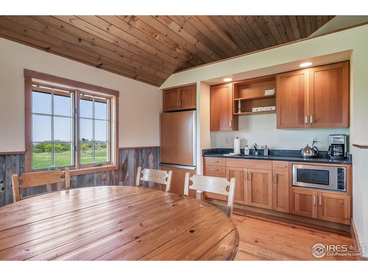 1355 South Cherryvale Road Boulder, CO 80303 - Photo 34 of 40 a open kitchen with granite countertop a stove top oven a sink dishwasher a dining table and chairs with wooden floor