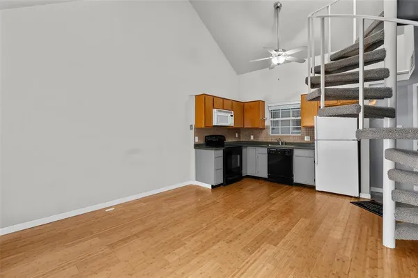 a view of a kitchen with stainless steel appliances wooden floor and a window