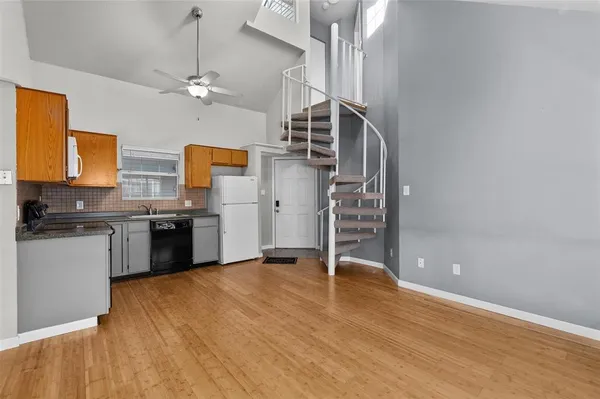 a kitchen with granite countertop a refrigerator stove top oven and sink