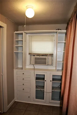 a kitchen with white cabinets and wooden floor