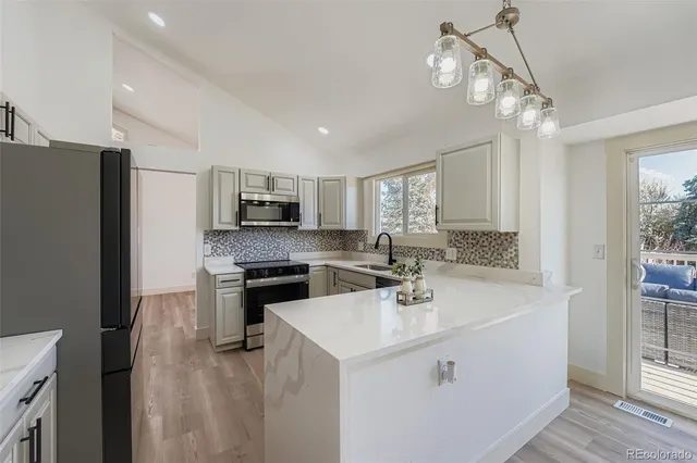 a kitchen with kitchen island a sink stainless steel appliances and window