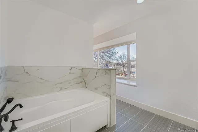 a bathroom with bathtub and window