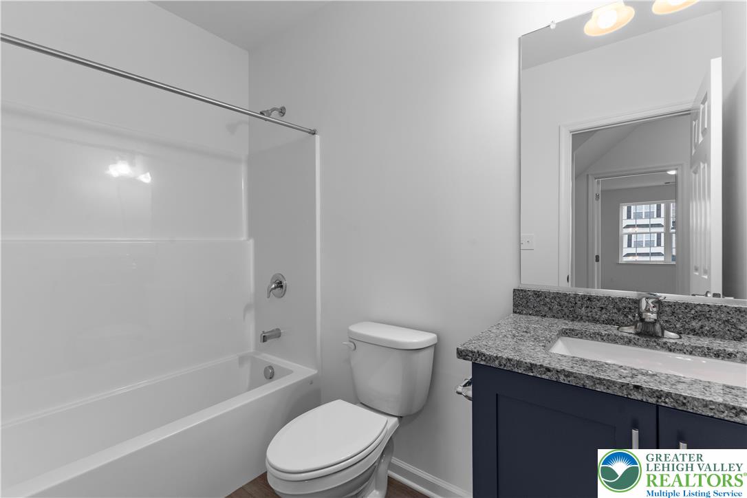 4929 Farrcroft Drive, Unit 83B Easton, PA 18040 - Photo 11 of 30 a bathroom with a granite countertop sink a toilet and shower