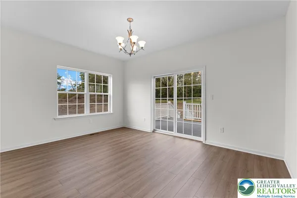 a view of a hallway with wooden floor and entryway