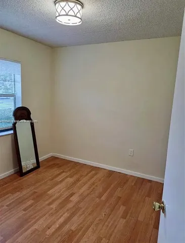 a view of a room with wooden floor and windows