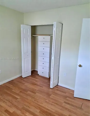 an empty room with wooden floor and closet