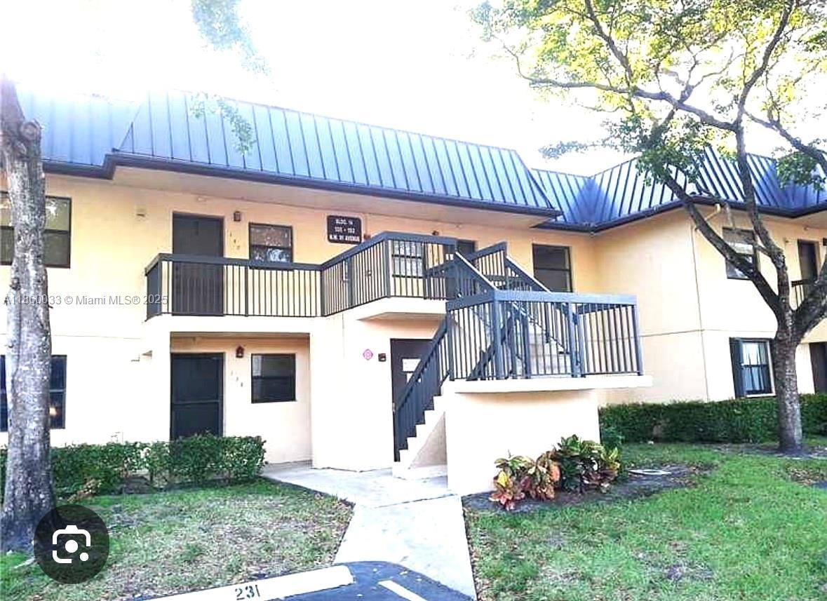 9317 Northwest 1st Court, Unit 105 Pembroke Pines, FL 33024 - Photo 4 of 25 a front view of a house with a garden and plants
