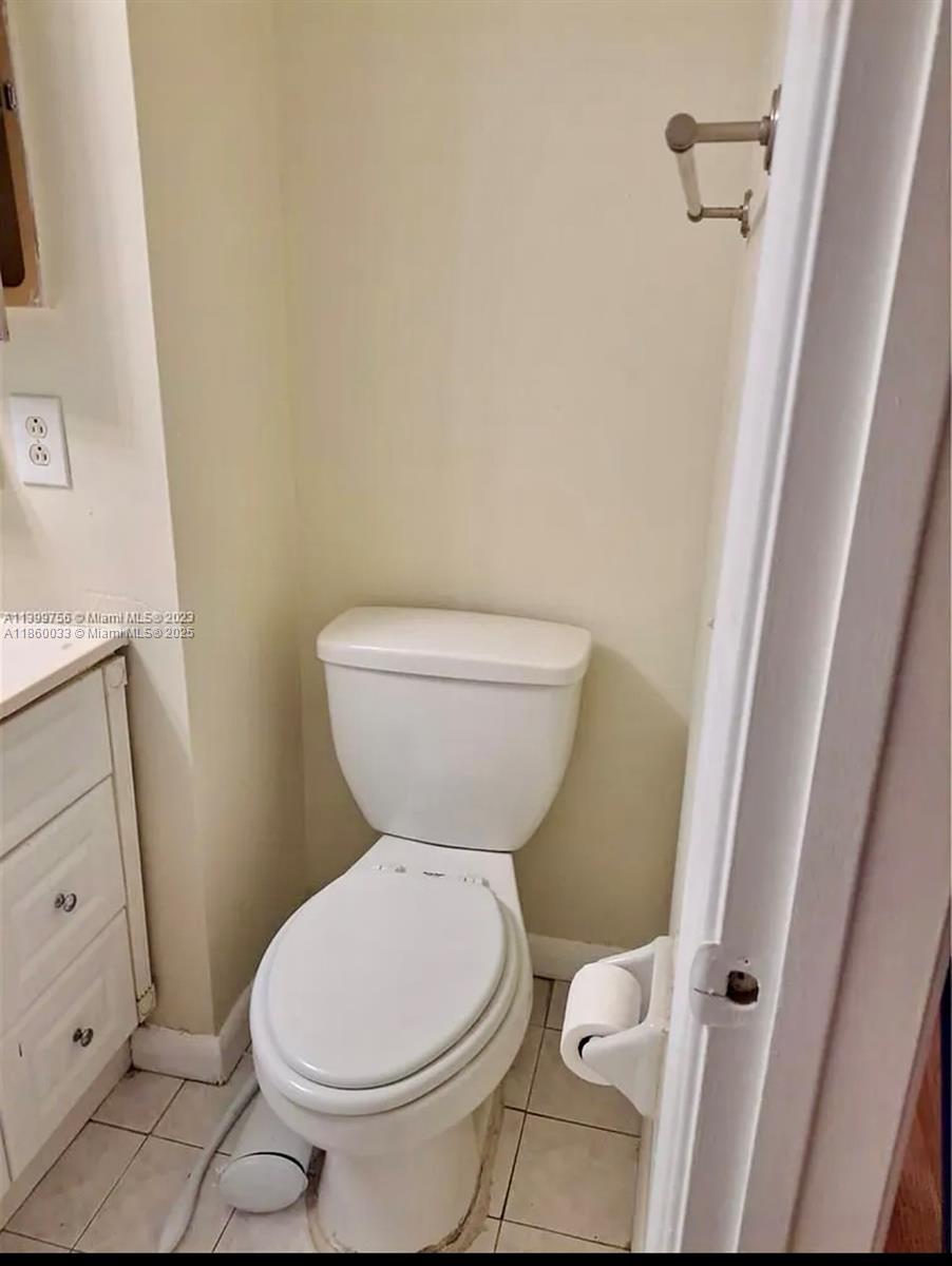 9317 Northwest 1st Court, Unit 105 Pembroke Pines, FL 33024 - Photo 7 of 25 a white toilet sitting next to a white sink and vanity