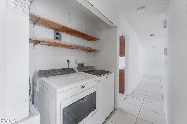 an empty room with chandelier fan and windows