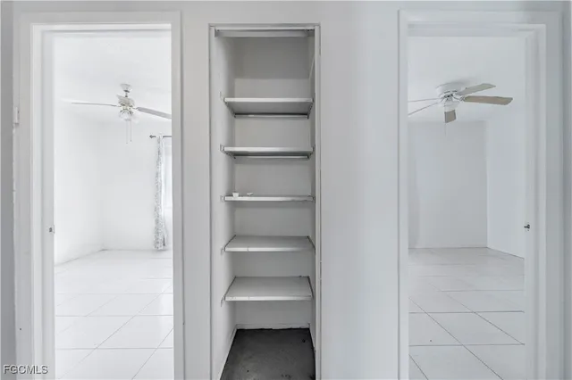 an empty room with chandelier fan