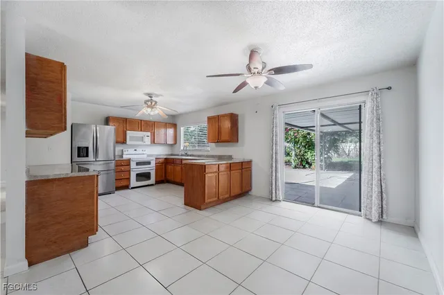a large white kitchen with a large window and a refrigerator