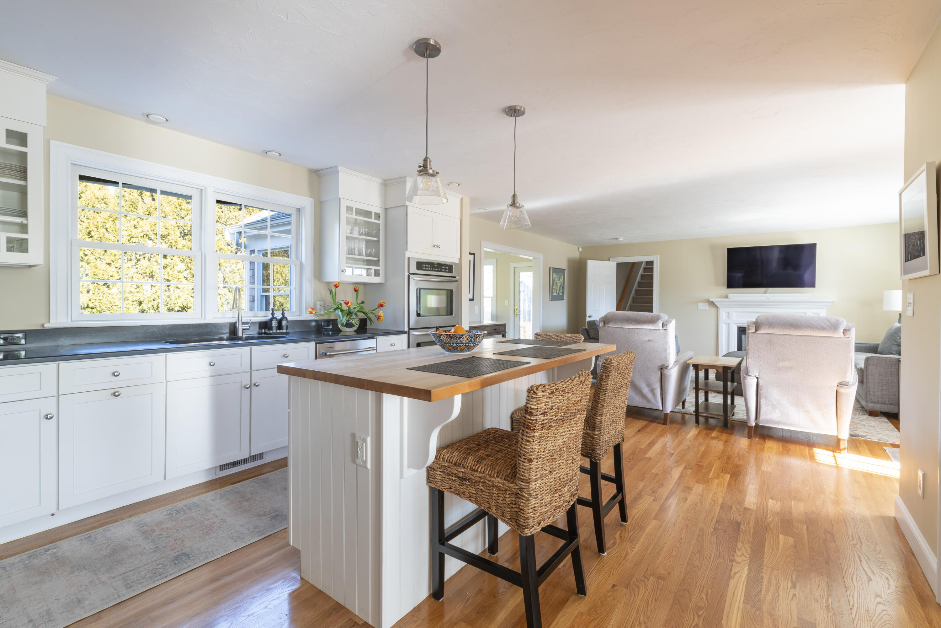 2 Parallel Street Harwich, MA 02645 - Photo 7 of 40 a open kitchen with stainless steel appliances granite countertop a stove a sink dishwasher a dining table and chairs with wooden floor