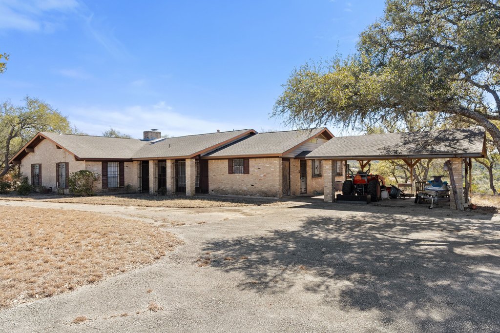 10904 Rawhide Trail Austin, TX 78736 - Photo 28 of 37 a front view of a house with a dirt yard and a large tree