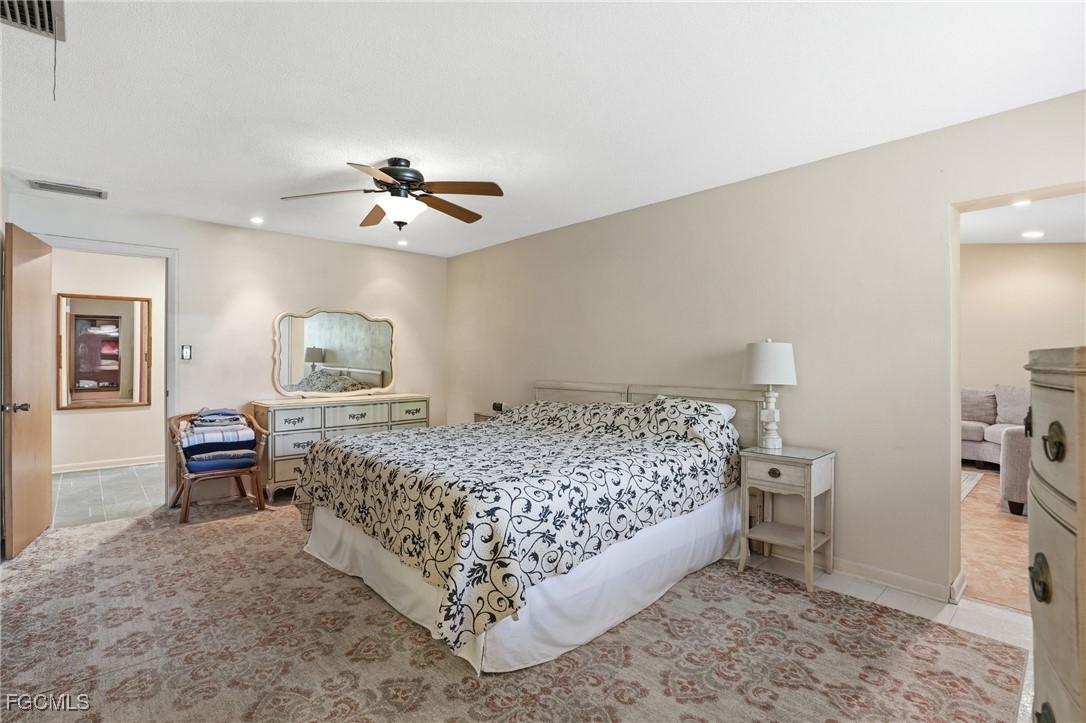 5541 Winkler Road Fort Myers, FL 33919 - Photo 15 of 22 a bedroom with a bed and a chandelier