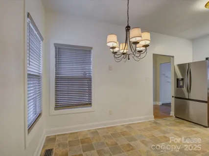 a view of a livingroom with a chandelier furniture and windows