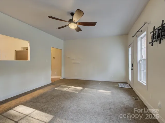 a view of a livingroom with a ceiling fan and window