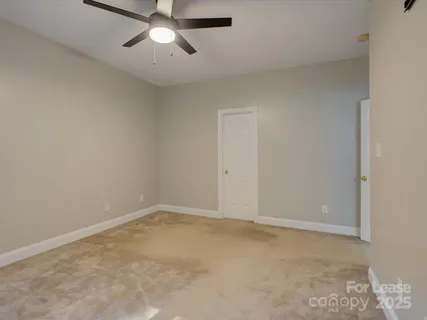 an empty room with a chandelier fan