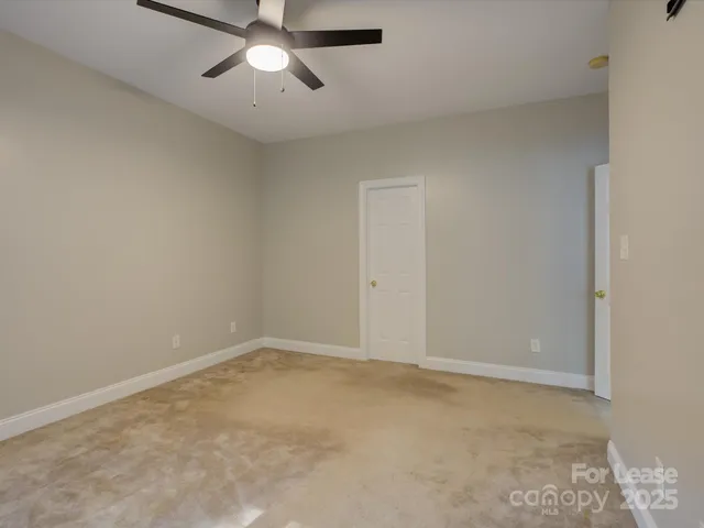 an empty room with a chandelier fan