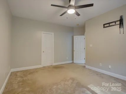 an empty room with a ceiling fan and a window