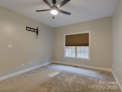 an empty room with a window and a ceiling fan