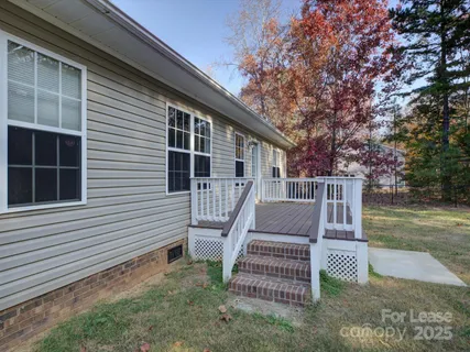 a view of a house with backyard and deck