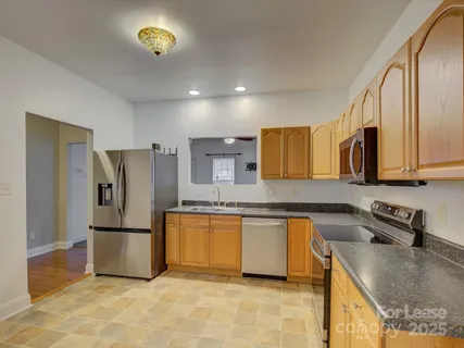 a kitchen with stainless steel appliances granite countertop a refrigerator a stove a sink and a refrigerator