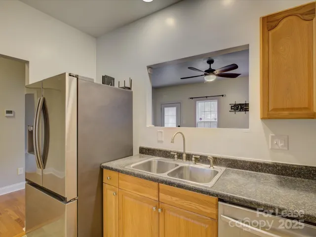 a kitchen with stainless steel appliances granite countertop a refrigerator and a sink