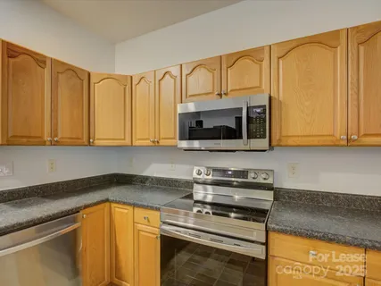 a kitchen with stainless steel appliances granite countertop a stove microwave and cabinets