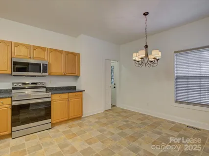 a view of a kitchen with stainless steel appliances granite countertop a stove and a sink with granite countertops