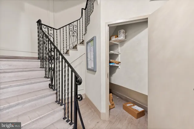 a view of staircase with wooden floor and white walls