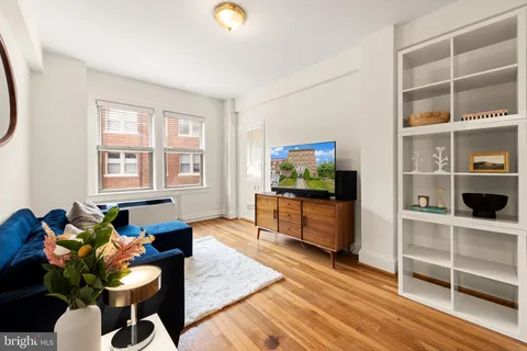 a living room with furniture a flat screen tv and wooden floor