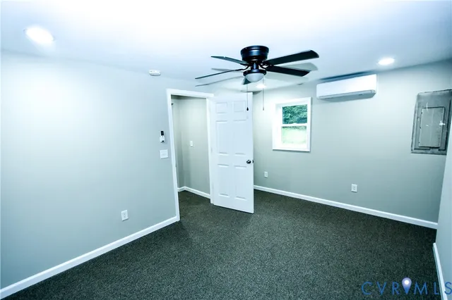an empty room with a ceiling fan and a window