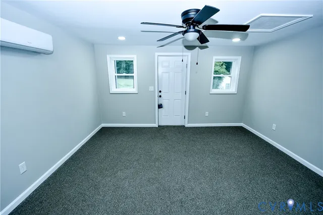 an empty room with a ceiling fan and window